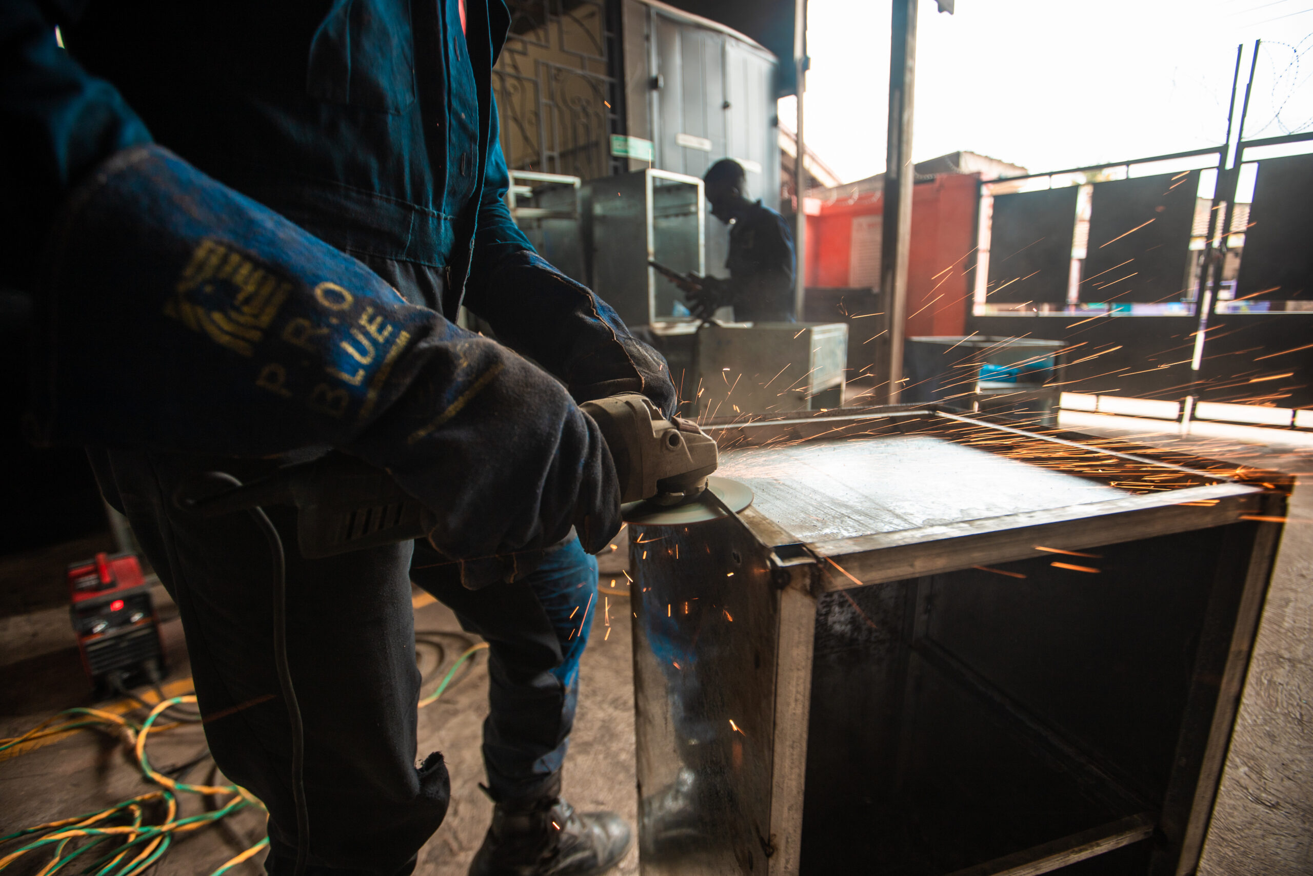 Worker in protective equipment operating a machine in the Accents and Art workshop