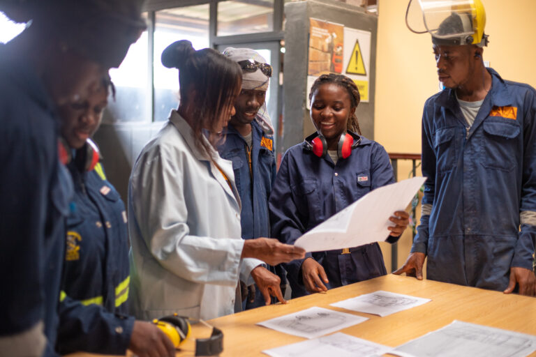 Accents & Art team in workshop overalls reviewing printed design drawings at a table