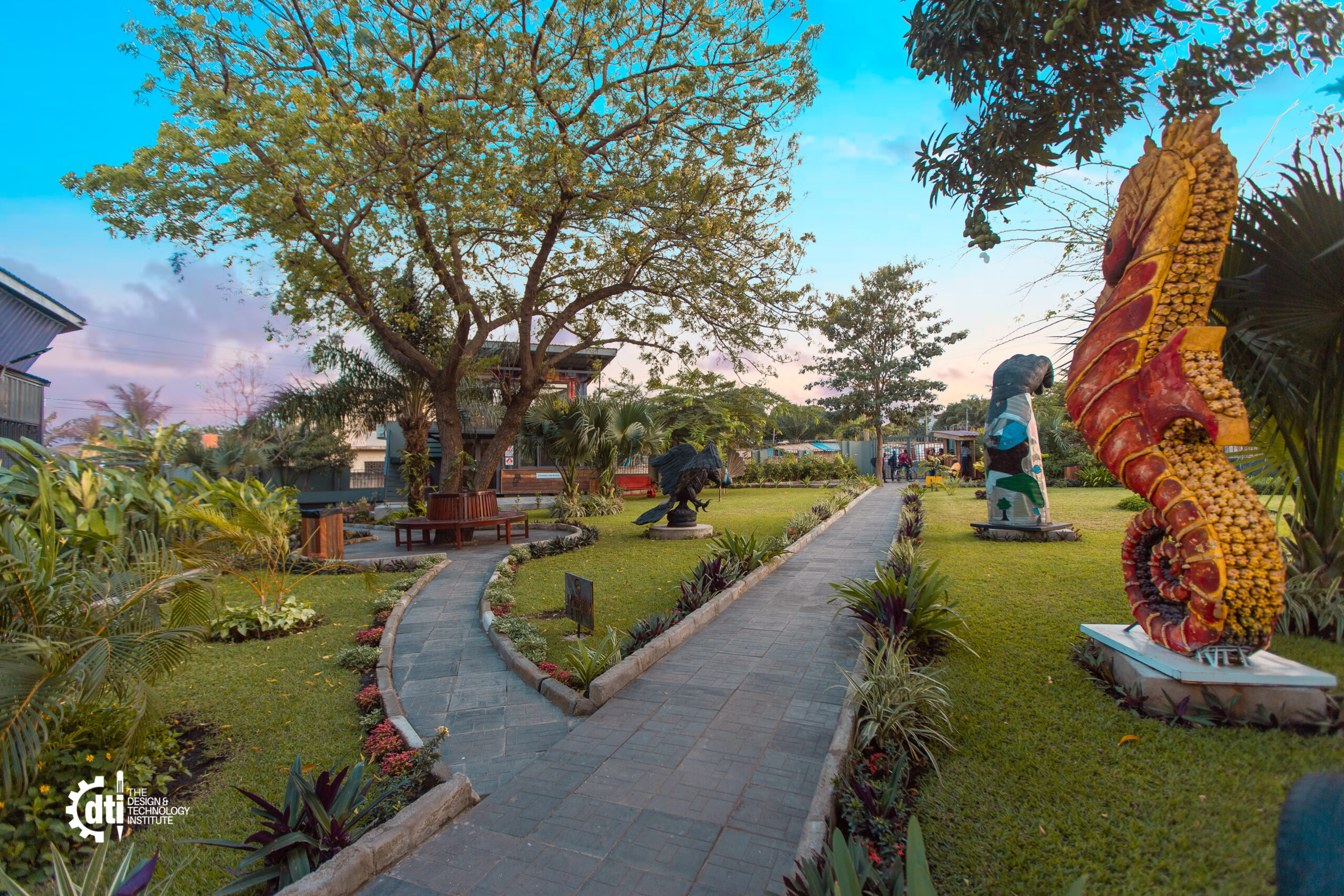 Landscaped walkway with paving, planting and a metal sculpture in the grounds