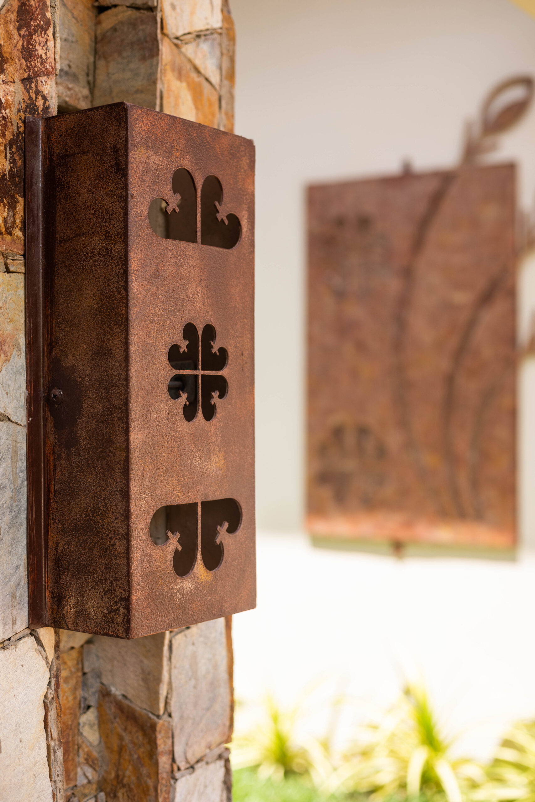 Copper panel engraved with adinkra symbols, close crop across the engraved line